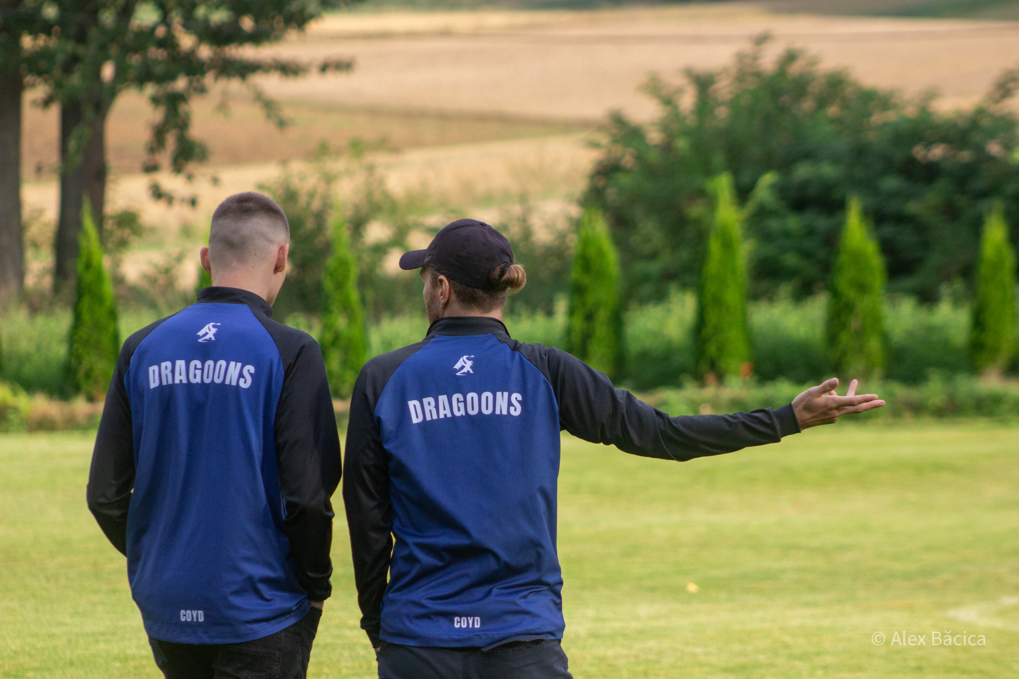 Two Krakow Dragoons FC players walking alongside on the pitch
